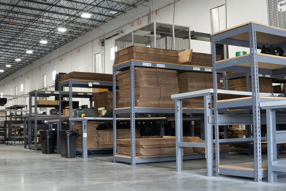 Quartermaster Logistics warehouse floor with packing workbenches