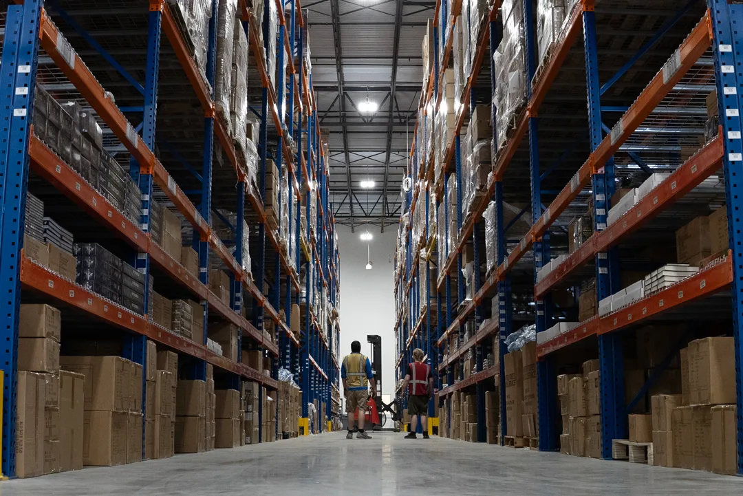 Inside the Quartermaster Logistics warehouse, with workers between tall shelves